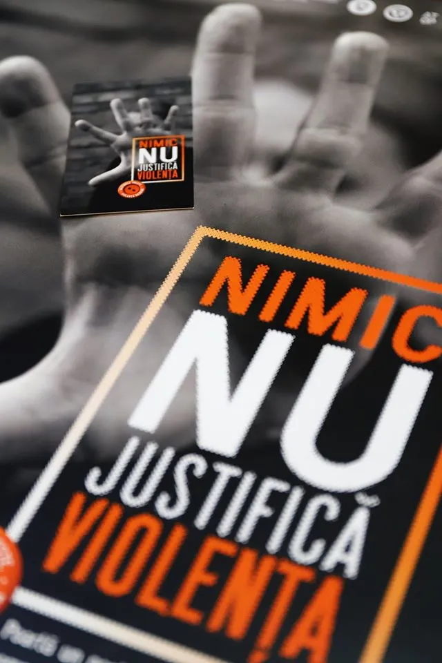 Kitárt tenyerű kéz nagyméretű fotója látható egy plakáton, rajta „NIMIC NU JUSTIFICĂ VIOLENȚA” (Semmi sem indokolja az erőszakot) felirat, mellette egy kisebb szórólap ugyanezzel az üzenettel és egy hasonló kéz-illusztrációval.