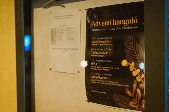 Hirdetőtáblára kitűzött plakát, amely az „Adventi hangoló” koncertsorozatot hirdeti a Gecse utcai templomban, mellette egy másik, nehezen olvasható papírlap látható.